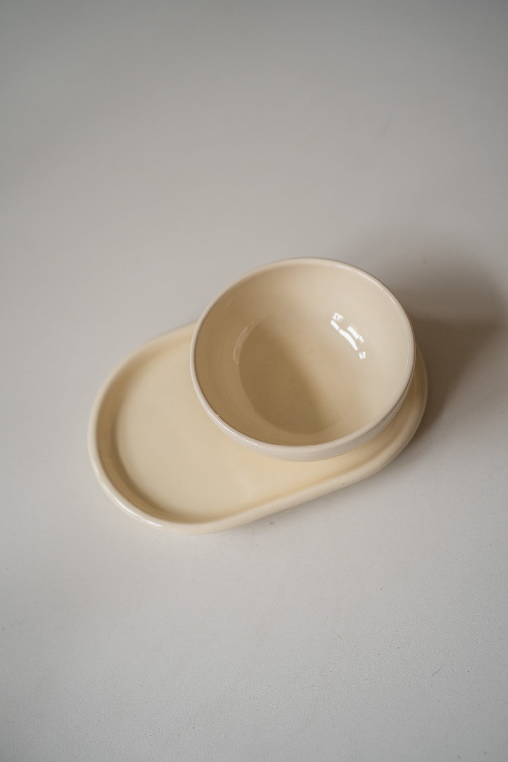 Crèmekleurige schaaltje en onderbord