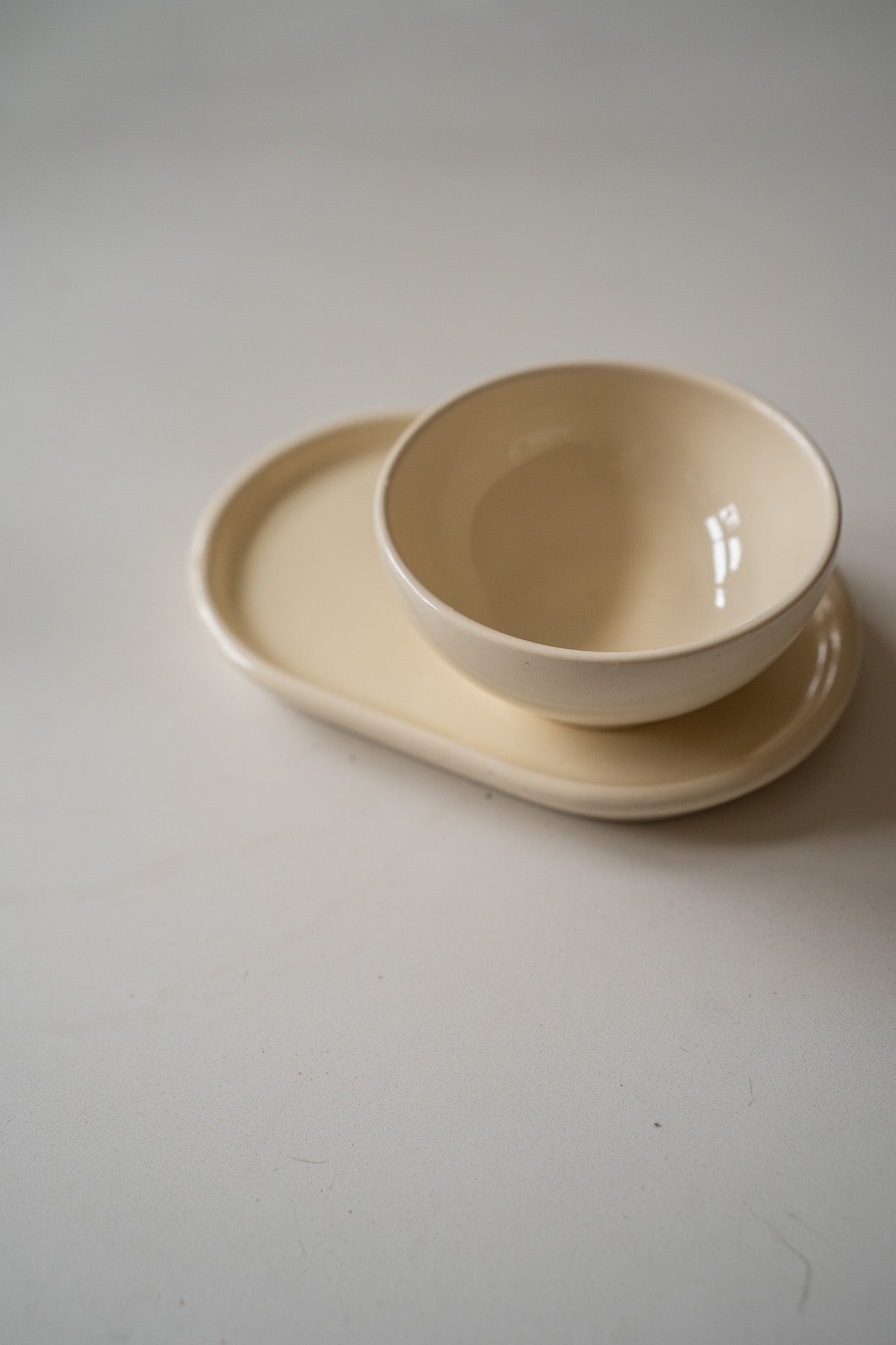 Crèmekleurige schaaltje en onderbord