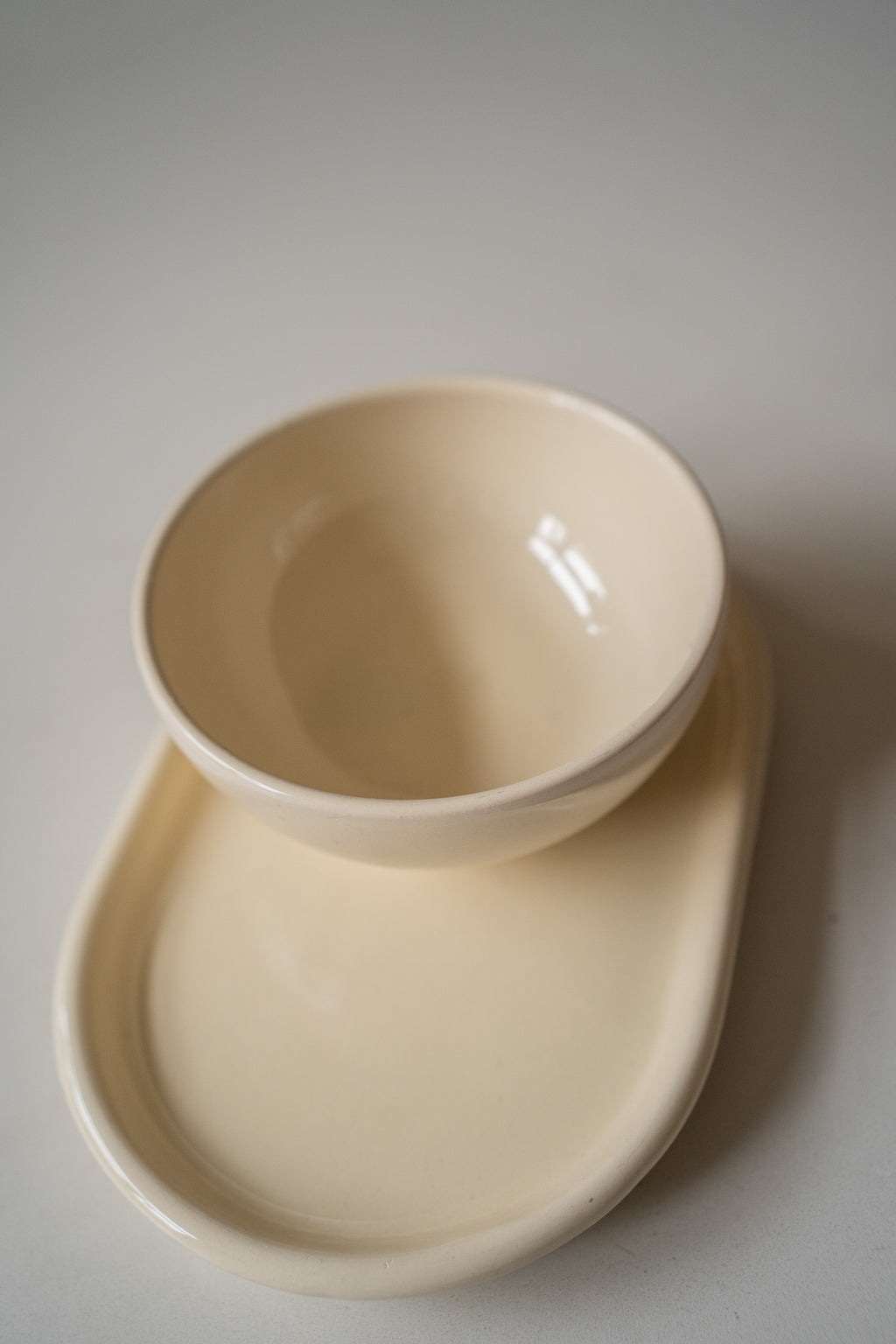 Crèmekleurige schaaltje en onderbord